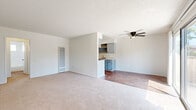 Located at 5189 Revere St in Chino, CA, this single-story, 1-bedroom, 1-bathroom residence offers a well-organized floor plan that makes efficient use of its space. The open-concept living and dining area features soft carpet flooring, a textured ceiling, and a ceiling fan with a built-in light fixture, creating a comfortable and functional common area. A wall-mounted heating unit serves the living space, and natural light filters in through several windows throughout the home. The galley-style kitchen is outfitted with light blue cabinetry, light quartz-style countertops, a gas range, and hardwood-style flooring, and opens visually to the dining area via a pass-through. The bedroom is a well-proportioned, carpeted retreat with a large window and direct access to both a dedicated closet and the full bathroom. The bathroom features a full tub-shower combo with white subway tile surround, chrome fixtures, and a window for natural ventilation. A sliding glass door in the dining area leads to a private, fenced patio, providing an outdoor space with views of mature trees and surrounding greenery. A hallway connects the main living areas to the bedroom and bathroom, completing the practical layout of this Chino residence.