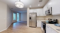 Located in the vibrant North Park neighborhood of San Diego, this well-designed 2-bedroom, 1-bathroom unit offers a clean, modern aesthetic throughout. Light wood-style flooring flows seamlessly across the entire space, creating a cohesive and bright atmosphere.

The open kitchen is a standout feature, showcasing crisp white shaker cabinetry extending to the ceiling, light countertops, and a full suite of stainless steel appliances including a French door refrigerator with ice maker, electric range, built-in microwave, and dishwasher. Recessed lighting and a stylish pendant fixture illuminate the kitchen and adjacent living area, which receives natural light through large windows and a glass door leading to the private balcony.

The spacious primary bedroom offers generous closet space with dual closets and direct access to the outdoors. The second bedroom is well-sized with warm neutral walls and ample natural light. Both rooms feature the same continuous wood-style flooring found throughout the unit.

The bathroom is finished in clean whites, featuring a tub/shower combination, a vanity with white cabinetry, and wood-style flooring that ties into the rest of the home. Neutral warm-toned walls throughout the unit contribute to an inviting and move-in ready atmosphere.