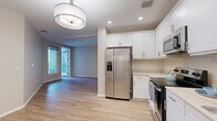 Located in the vibrant North Park neighborhood of San Diego, this well-designed 2-bedroom, 1-bathroom unit offers a clean, modern aesthetic throughout. Light wood-style flooring flows seamlessly across the entire space, creating a cohesive and bright atmosphere.

The open kitchen is a standout feature, showcasing crisp white shaker cabinetry extending to the ceiling, light countertops, and a full suite of stainless steel appliances including a French door refrigerator with ice maker, electric range, built-in microwave, and dishwasher. Recessed lighting and a stylish pendant fixture illuminate the kitchen and adjacent living area, which receives natural light through large windows and a glass door leading to the private balcony.

The spacious primary bedroom offers generous closet space with dual closets and direct access to the outdoors. The second bedroom is well-sized with warm neutral walls and ample natural light. Both rooms feature the same continuous wood-style flooring found throughout the unit.

The bathroom is finished in clean whites, featuring a tub/shower combination, a vanity with white cabinetry, and wood-style flooring that ties into the rest of the home. Neutral warm-toned walls throughout the unit contribute to an inviting and move-in ready atmosphere.