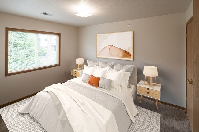 Highland Meadows Apartments in Bellevue, NE Comfortable Bedroom with Large Window and Plush Bed - Highland Meadows