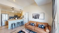 Located at 251 E Las Animas St in Colorado Springs, CO, this thoughtfully designed 2-bedroom, 2-bathroom unit offers a efficient and functional single-floor layout. The open-concept living and kitchen area creates a welcoming, connected space anchored by light-toned luxury vinyl plank flooring throughout. The kitchen is outfitted with stainless steel appliances, natural wood cabinetry, blue tile backsplash, white quartz countertops, and a peninsula with bar seating and pendant lighting — ideal for both cooking and casual dining. The living room features a sliding glass door that opens to a private balcony, filling the space with natural light and offering outdoor views. The primary bedroom is a serene retreat with elevated ceilings and access to a well-appointed bathroom featuring a wood-toned vanity, white quartz countertop, and a walk-in closet with built-in shelving. The second bathroom includes a full tub-shower combo with large-format tile surround. Both bedrooms offer a calm, neutral palette with soft carpeting. The unit's clean, modern aesthetic, efficient use of space, and quality finishes make it a comfortable and stylish home in the heart of Colorado Springs.