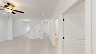 Located at 212 Commercial Dr in Athens, Alabama, this single-story, 2-bedroom, 2-bathroom home offers a thoughtfully designed floor plan with a bright, contemporary aesthetic throughout. The interior is unified by large-format light-toned tile flooring and crisp white walls, creating a clean and airy atmosphere in every room.

The open-concept kitchen is a standout feature, outfitted with white shaker-style cabinetry, sleek quartz-style countertops, and a full suite of stainless steel appliances including a refrigerator with ice maker, electric range, over-the-range microwave, and dishwasher. Black hardware accents add a modern contrast throughout. The adjacent dining area connects seamlessly to the kitchen, while the spacious living room benefits from recessed lighting, a ceiling fan, and natural light streaming through window treatments.

Both bedrooms are generously proportioned, each equipped with ceiling fans and windows dressed with horizontal blinds. The primary bedroom offers a comfortable, well-lit retreat. The bathrooms maintain the home's clean design language, with one featuring a walk-in shower with a built-in bench seat and matte black fixtures.

A central hallway connects the living spaces to the private quarters, maintaining a logical and functional flow. The overall ambiance is modern, move-in ready, and well-suited for comfortable everyday living.