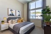 Located at 27931 Cabot Rd in Laguna Niguel, California, this contemporary single-floor residence showcases an elevated design highlighted by soaring ceilings and expansive floor-to-ceiling windows that frame sweeping panoramic views of the surrounding landscape and distant mountains. The open-concept living area is anchored by a dramatic corner window configuration, flooding the space with abundant natural light and creating a bright, airy atmosphere. A private balcony extends the living space outdoors, offering additional opportunities to enjoy the scenic surroundings.

The kitchen is well-appointed with stainless steel appliances, dark wood and two-tone cabinetry, light quartz countertops, a gas cooktop island with seating, and a statement range hood that extends to the ceiling. Light wood-style flooring runs throughout the main living areas, complementing the modern aesthetic.

The bedrooms are generously proportioned, featuring plush carpeting, tall windows with city views, and ample natural light. Two bathrooms serve the residence — the primary bath includes a soaking tub, glass-enclosed shower, elongated dual vanity with dark wood cabinetry, and light quartz countertops, while the secondary bath offers a single vanity with similar finishes. An in-unit laundry area with a full-size washer and dryer adds everyday convenience to this polished Laguna Niguel residence.