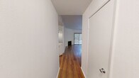 Located at 15130 Dickens St in the Sherman Oaks neighborhood of Los Angeles, this single-level unit offers three bedrooms and four bathrooms within a thoughtfully arranged floor plan. Warm hardwood flooring flows throughout the main living areas and bedrooms, lending a cohesive and inviting aesthetic to the space. The living room serves as a central gathering area, highlighted by a classic white-mantled fireplace that adds character and warmth. An open pass-through connects the living area to the kitchen, which features crisp white cabinetry, light quartz countertops, a peninsula breakfast bar, and a full suite of stainless steel appliances including a gas range, microwave, and dishwasher. The primary bedroom is generously sized and includes access to a dedicated closet, with natural light provided by a large window. Additional bedrooms are well-proportioned, with vertical blinds on windows and sliding glass doors offering outdoor access in at least one room. The four bathrooms are finished in light tile with white vanities and well-lit mirrors, providing ample facilities for residents and guests. The unit is surrounded by lush greenery, visible from multiple windows and lending a serene, tree-lined ambiance to everyday living.