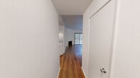 Located at 15130 Dickens St in the Sherman Oaks neighborhood of Los Angeles, this single-level unit offers three bedrooms and four bathrooms within a thoughtfully arranged floor plan. Warm hardwood flooring flows throughout the main living areas and bedrooms, lending a cohesive and inviting aesthetic to the space. The living room serves as a central gathering area, highlighted by a classic white-mantled fireplace that adds character and warmth. An open pass-through connects the living area to the kitchen, which features crisp white cabinetry, light quartz countertops, a peninsula breakfast bar, and a full suite of stainless steel appliances including a gas range, microwave, and dishwasher. The primary bedroom is generously sized and includes access to a dedicated closet, with natural light provided by a large window. Additional bedrooms are well-proportioned, with vertical blinds on windows and sliding glass doors offering outdoor access in at least one room. The four bathrooms are finished in light tile with white vanities and well-lit mirrors, providing ample facilities for residents and guests. The unit is surrounded by lush greenery, visible from multiple windows and lending a serene, tree-lined ambiance to everyday living.