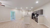 Located at 3151 Boulevard De Sevilla Blvd in Foley, Alabama, this single-floor residence offers a clean, modern design with thoughtfully selected finishes throughout. The open-concept kitchen and living area serves as the heart of the home, featuring light wood-look flooring, recessed lighting, and a central island with granite countertops. The kitchen is equipped with dark gray cabinetry, stainless steel appliances including a refrigerator, range, and microwave, providing both style and functionality. The spacious living area features a ceiling fan and a window that fills the space with natural light, while an open passage connects seamlessly to the rest of the unit. The bedrooms are carpeted for comfort, each featuring ceiling fans, neutral-toned walls, and windows that offer natural light and outdoor views of the surrounding landscape. Closet access is provided in select bedrooms. Two bathrooms carry the same consistent design language, with wood-look tile flooring, dark vanity cabinetry, and granite countertops. One bathroom includes a tub-shower combination, while the other features a standalone shower. The overall aesthetic is clean, contemporary, and move-in ready, with neutral tones and modern fixtures creating a cohesive and welcoming atmosphere throughout.