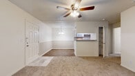Located at 5450 Desoto Pkwy in Sarasota, Florida, this single-floor residence offers a thoughtfully laid-out interior with a clean, neutral aesthetic throughout. The galley-style kitchen is well-equipped, featuring white cabinetry with brushed hardware, a stone-look granite countertop, a mosaic tile backsplash, and white appliances including a range, microwave, and refrigerator. A peninsula with matching granite countertop connects the kitchen to the living and dining area, providing a convenient pass-through and casual seating opportunity. The open living and dining space is bright and welcoming, with a ceiling fan with light fixture overhead, a pendant light above the dining area, and a combination of hardwood-style flooring and plush carpeting that defines each zone. A door leads out to a private balcony or patio, allowing natural light to filter in. The bedrooms are carpeted and generously sized, each with windows dressed in blinds that provide natural light and privacy. The bathroom is finished with wood-look flooring, white cabinetry, a marble-look countertop vanity, a framed mirror, and a tiled shower surround, creating a clean and polished look. Additional storage is available through built-in shelving and closet space throughout the unit. Textured ceilings are consistent throughout the space.
