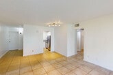 Located in Hollywood, FL, this single-floor, 2-bedroom, 1-bathroom home offers a practical and well-organized layout. The combined living and dining area is bright and open, featuring light ceramic tile flooring throughout and a large sliding glass door that floods the space with natural light and opens to a view of lush green lawn. A dedicated entrance leads into a hallway connecting the main living areas, with four closets providing generous storage throughout the unit. The kitchen is efficiently designed with white cabinetry, granite-style countertops, a stainless steel refrigerator, electric range, and dishwasher, complemented by a window that brings in additional natural light. Both bedrooms are carpeted and offer a comfortable, quiet retreat — the primary bedroom features a wide, louvered bi-fold closet spanning nearly the full wall. The second bedroom is accessed conveniently near the in-unit laundry area. The bathroom is clean and functional, featuring a full tub-shower combination with white tile surround and modern chrome fixtures. Throughout the home, textured ceilings, white walls, and consistent flooring choices create a cohesive, light-filled atmosphere well-suited to South Florida living.