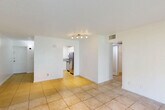 Located in Hollywood, FL, this single-floor, 2-bedroom, 1-bathroom home offers a practical and well-organized layout. The combined living and dining area is bright and open, featuring light ceramic tile flooring throughout and a large sliding glass door that floods the space with natural light and opens to a view of lush green lawn. A dedicated entrance leads into a hallway connecting the main living areas, with four closets providing generous storage throughout the unit. The kitchen is efficiently designed with white cabinetry, granite-style countertops, a stainless steel refrigerator, electric range, and dishwasher, complemented by a window that brings in additional natural light. Both bedrooms are carpeted and offer a comfortable, quiet retreat — the primary bedroom features a wide, louvered bi-fold closet spanning nearly the full wall. The second bedroom is accessed conveniently near the in-unit laundry area. The bathroom is clean and functional, featuring a full tub-shower combination with white tile surround and modern chrome fixtures. Throughout the home, textured ceilings, white walls, and consistent flooring choices create a cohesive, light-filled atmosphere well-suited to South Florida living.