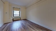 Located on Tremont Street in Boston's vibrant Back Bay neighborhood (02116), this single-floor unit offers a thoughtfully laid-out living space with consistent finishes throughout. The main living area features light-toned hardwood-style flooring and neutral walls adorned with classic crown molding, lending a clean and timeless character to the room. A window with a roller shade allows natural light to filter in while maintaining privacy, and a baseboard heating unit ensures year-round comfort.

The kitchen is efficiently designed and well-equipped, showcasing rich dark-stained cabinetry with sleek hardware, granite countertops with an undermount stainless steel sink, and a four-burner electric range with an overhead ventilation hood. White subway tile serves as the backsplash, tying the space together with a modern yet classic aesthetic.

The bathroom continues the cohesive design language with white subway tile walls, a granite-topped dark wood vanity with an undermount sink, a framed mirror, and a glass-enclosed tub and shower combination. The overall ambiance of the unit is clean, functional, and polished, making it well-suited for urban living in one of Boston's most walkable and historically rich neighborhoods.