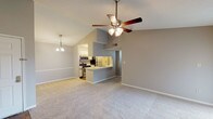 Located at 9991 Arbor Montgomery Ln in Cincinnati, Ohio, this single-floor residence offers a thoughtfully designed layout with a welcoming open-concept living and dining area. The main living space is highlighted by soaring vaulted ceilings and a ceiling fan, creating an airy and spacious atmosphere. Soft carpeting flows throughout the living areas and bedrooms, complemented by warm neutral gray walls.

The galley-style kitchen is well-equipped with stainless steel appliances, including a range, microwave, and refrigerator, set beneath track lighting. Light wood-tone flooring, ample cabinetry, and a pass-through breakfast bar connect the kitchen seamlessly to the living space.

The primary bedroom is generously sized, benefiting from natural light through a window, and features both a walk-in closet with built-in shelving and an additional closet for abundant storage. The en-suite bathroom includes a tub/shower combination, a vanity with sink, and durable wood-look flooring. A secondary bedroom offers plush carpeting and a sliding glass door opening to an outdoor area, admitting plenty of natural light. Additional rooms feature windows with blinds and easy outdoor access, rounding out this comfortable, functional residence.