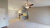 Located at 9991 Arbor Montgomery Ln in Cincinnati, Ohio, this single-floor residence offers a thoughtfully designed layout with a welcoming open-concept living and dining area. The main living space is highlighted by soaring vaulted ceilings and a ceiling fan, creating an airy and spacious atmosphere. Soft carpeting flows throughout the living areas and bedrooms, complemented by warm neutral gray walls.

The galley-style kitchen is well-equipped with stainless steel appliances, including a range, microwave, and refrigerator, set beneath track lighting. Light wood-tone flooring, ample cabinetry, and a pass-through breakfast bar connect the kitchen seamlessly to the living space.

The primary bedroom is generously sized, benefiting from natural light through a window, and features both a walk-in closet with built-in shelving and an additional closet for abundant storage. The en-suite bathroom includes a tub/shower combination, a vanity with sink, and durable wood-look flooring. A secondary bedroom offers plush carpeting and a sliding glass door opening to an outdoor area, admitting plenty of natural light. Additional rooms feature windows with blinds and easy outdoor access, rounding out this comfortable, functional residence.
