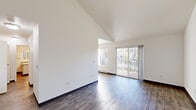 Located at 380 NW Gina Way in Beaverton, Oregon, this 2-bedroom, 2-bathroom single-floor residence offers a thoughtfully arranged layout with a variety of appealing architectural details. The living room is an immediate standout, featuring soaring vaulted ceilings and rich hardwood-style flooring that lend the space a bright, open feel. A sliding glass door opens to a private balcony, flooding the room with natural light and providing pleasant outdoor views of the surrounding neighborhood and mature trees. The kitchen is equipped with white cabinetry with wood-trimmed accents, a stainless steel gas range, and a ceiling fan overhead. A large window brings in additional natural light, and the hardwood-style flooring continues seamlessly throughout. Both bedrooms are carpeted for comfort and feature large windows that invite natural light and neighborhood views. The generously sized primary bedroom includes its own dedicated closet with a full hanging rod, while the second bedroom also benefits from dual windows and ample space. Two bathrooms serve the home, one featuring tile-style flooring, a soaking tub, and a vanity with a stone-look countertop. Two hallways connect the rooms efficiently, and two closets provide practical storage throughout.