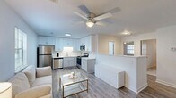 Located at 3300 Evans St in Greenville, NC, this 2-bedroom, 1-bathroom unit offers a thoughtfully designed single-floor layout. The open-concept living and kitchen area serves as the heart of the home, featuring light wood-style flooring, bright white walls, and a ceiling fan overhead. The kitchen is well-equipped with stainless steel appliances — including a refrigerator, dishwasher, microwave, and range — complemented by white shaker-style cabinetry, light countertops, and a functional layout that maximizes the available space. Natural light filters in through windows, adding to the airy, clean aesthetic. A dining nook adjacent to the living area provides a dedicated space for meals. The primary bedroom offers comfortable proportions, plush carpeting, a ceiling fan, a built-in closet, and a window with outdoor views. The second bedroom, also carpeted with a ceiling fan and window, is versatile enough to serve as a home office or guest room. The bathroom is clean and practical, featuring a tub/shower combo with a curved curtain rod, a vanity, and neutral finishes throughout. The unit presents a cohesive, modern aesthetic with a bright, neutral palette that makes the space feel open and welcoming.