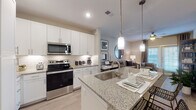 Located at 625 Creekside Way in New Braunfels, Texas, this single-floor residence offers a thoughtfully designed open-concept layout that seamlessly connects the kitchen, dining, and living areas. The kitchen is a standout feature, showcasing white shaker cabinetry, granite countertops, a classic subway tile backsplash, and a full suite of stainless steel appliances including a French door refrigerator, electric range, microwave, and dishwasher. A central island with an undermount sink and pendant lighting serves as both a functional workspace and a casual dining area. Light wood-style flooring flows throughout, complementing the neutral color palette that lends the space a clean, modern aesthetic. The living area provides a comfortable and inviting atmosphere, anchored by a ceiling fan and natural light from large windows dressed with blinds and draping curtains. The bedroom is a serene retreat, featuring a generous window that fills the room with natural light, direct access to a walk-in closet, and a private en-suite bathroom. The bathroom is finished with granite-topped white cabinetry, a large mirror, and a soaking tub with shower. A second bathroom with similar finishes offers added convenience. Every detail reflects a contemporary and cohesive design sensibility throughout.