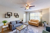 This well-organized one-bedroom, one-bathroom residence in Dalton, Georgia, offers a practical and comfortable single-floor layout. The combined kitchen and living room serves as the heart of the home, where large windows invite generous natural light throughout the day. The living area features plush carpeted flooring, a ceiling fan with light fixture, and a textured ceiling, creating a cozy yet functional space for relaxing or entertaining. The kitchen is efficiently designed with white cabinetry, light stone-effect countertops, black appliances including a refrigerator, electric range, and dishwasher, complemented by a window above the sink and durable wood-look vinyl flooring. The bedroom is a comfortable retreat with soft carpet, a window with outdoor views, and a textured ceiling that carries through the home's consistent style. The bathroom is clean and straightforward, featuring a full tub-shower combination with chrome fixtures and a patterned shower curtain. Throughout the residence, neutral wall tones provide a versatile backdrop, and the thoughtful layout ensures every square foot is purposefully utilized, making this an ideal space for those seeking simplicity and functionality in Dalton, GA.
