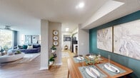 This single-floor residence offers three bedrooms and two bathrooms within a thoughtfully arranged floor plan. The open-concept layout seamlessly connects the living room, dining area, and kitchen, creating a cohesive social space. The living room is a standout area, featuring light-filtering sliding glass doors that open to an outdoor space with direct waterfront views, a ceiling fan, light wood-style flooring, and a textured accent wall that adds depth and character.

The dining area is distinguished by a bold teal accent wall, recessed lighting, and direct sightlines to both the living room and kitchen, reinforcing the open flow of the space. The galley-style kitchen features white cabinetry with sleek hardware, light quartz countertops, tile backsplash, stainless steel appliances, and a skylight that brings in natural light.

The primary bedroom accommodates a full-sized bed comfortably, includes a ceiling fan, large window with waterfront views, and access to a dedicated walk-in closet with wire shelving. The bathrooms are finished with white tile tub-surround, wood-style flooring, white vanities, and dark accent walls. Light wood-style flooring runs throughout the residence, contributing to a consistent and cohesive aesthetic.