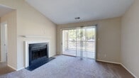 Located at 4401 Hamptonridge Drive in Charlotte, NC, this 2-bedroom, 1-bathroom single-floor home offers a well-designed layout with comfortable living spaces throughout. The living room is a standout area, featuring vaulted ceilings, plush carpeting, and a classic wood-burning fireplace framed by a clean white mantel. A sliding glass door floods the room with natural light and opens directly onto a private balcony overlooking lush, mature trees — ideal for relaxing outdoors. The kitchen is well-appointed with dark espresso cabinetry, granite countertops, stainless steel appliances including a range, microwave, and refrigerator, and durable hardwood-style flooring that adds warmth and contrast. The full bathroom continues the cohesive design with granite-topped dark wood vanity, hardwood-style tile flooring, and a tiled shower/tub combination. Both bedrooms are carpeted and filled with natural light from large windows. The spacious primary bedroom includes a walk-in closet, offering generous storage. The second bedroom is equally comfortable and versatile. Neutral tones throughout the home create a clean, welcoming ambiance suited for a variety of interior styles.