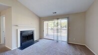 Located at 4401 Hamptonridge Drive in Charlotte, NC, this 2-bedroom, 1-bathroom single-floor home offers a well-designed layout with comfortable living spaces throughout. The living room is a standout area, featuring vaulted ceilings, plush carpeting, and a classic wood-burning fireplace framed by a clean white mantel. A sliding glass door floods the room with natural light and opens directly onto a private balcony overlooking lush, mature trees — ideal for relaxing outdoors. The kitchen is well-appointed with dark espresso cabinetry, granite countertops, stainless steel appliances including a range, microwave, and refrigerator, and durable hardwood-style flooring that adds warmth and contrast. The full bathroom continues the cohesive design with granite-topped dark wood vanity, hardwood-style tile flooring, and a tiled shower/tub combination. Both bedrooms are carpeted and filled with natural light from large windows. The spacious primary bedroom includes a walk-in closet, offering generous storage. The second bedroom is equally comfortable and versatile. Neutral tones throughout the home create a clean, welcoming ambiance suited for a variety of interior styles.