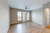 Located at 12401 Boulder Springs Pkwy in Maryland Heights, MO, this well-appointed 3-bedroom, 3-bathroom single-floor residence offers a thoughtfully designed layout with modern finishes throughout. The heart of the home is an open-concept living, dining, and kitchen area, where light wood-tone flooring flows seamlessly underfoot. The kitchen is a standout feature, showcasing white shaker cabinetry, a classic subway tile backsplash, stainless steel appliances, and a curved central island with a dark stone countertop and pendant lighting overhead. The living area benefits from generous natural light through large windows and a glass door leading to an outdoor balcony, complemented by a ceiling fan above. Three well-proportioned bedrooms provide comfortable accommodations, with the primary bedroom offering a spacious footprint; secondary bedrooms feature neutral carpet and ample closet space. The three bathrooms are finished with granite-topped white vanities and tiled tub-shower combinations. Connecting the spaces are clean, well-lit hallways with wood-tone flooring. Additional practical amenities include a dedicated laundry room and utility room, rounding out this complete and functional residence.