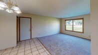 Located at 205 Briargate Rd in Mankato, Minnesota, this single-floor unit offers a practical and comfortable layout suited for everyday living. The entry area transitions between light ceramic tile flooring and plush carpet, clearly defining the functional zones throughout the space.

The living area is generously sized, featuring soft carpet underfoot and a large sliding window that frames views of the surrounding green lawn and neighboring buildings. Natural light flows freely into the room, creating a bright and welcoming atmosphere. A textured ceiling adds subtle visual interest overhead.

The dining area connects seamlessly to the kitchen and is highlighted by a modest chandelier overhead, with tile flooring continuing through this zone. The kitchen is efficiently designed with warm oak cabinetry above and below the counters, a double stainless steel sink, coil-top electric range, and a ventilation hood — providing all the essentials in a compact, well-organized space.

The bedrooms are carpeted and well-lit, each featuring wood-trimmed windows that overlook the outdoor green space, offering a calm and pleasant view. The bathrooms are finished with tile flooring and include a full tub-shower combination, a toilet, and a vanity with oak cabinetry, maintaining a consistent and functional design throughout the unit.