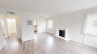 This 2-bedroom, 1-bathroom residence at 80 Forest Grove Dr in Daly City, CA offers a clean, modern aesthetic across a single well-organized floor. The living room serves as the heart of the home, highlighted by a classic wood-burning fireplace with a white surround and black brick interior. Light-toned wood-style flooring runs throughout the entire unit, complementing the crisp white walls and creating a cohesive, bright atmosphere. Multiple windows fitted with white blinds allow natural light to fill the space, further enhancing its open feel. A ceiling fan adds both function and a finishing detail to the living area. The kitchen features white cabinetry and light countertops, maintaining the home's clean and neutral design language. A hallway connects the main living areas to the two bedrooms and a dedicated closet, providing practical organization. The primary bedroom is a comfortable size, with a window for natural light and warm wood-style flooring. The second bedroom mirrors the same clean design with its own window and ample space. The bathroom is well-appointed with a tub-shower combo featuring marble-style surround walls, a white vanity with cabinet storage, a wall mirror, and a window for ventilation. The unit's consistent finishes and thoughtful layout make it an efficient and inviting home.