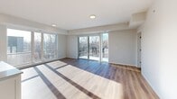Located at 2800 N Wayzata Blvd in Minneapolis, MN, this well-appointed 3-bedroom, 3-bathroom unit offers a thoughtfully designed single-floor layout with a clean, contemporary aesthetic throughout. The open-concept living area is anchored by large sliding glass doors that flood the space with natural light and provide views of the surrounding cityscape. Hardwood-style flooring runs through the main living areas, complementing the neutral, light-toned walls that give the unit a bright and airy feel. The kitchen features white cabinetry, a tile backsplash, and stainless steel appliances, flowing seamlessly into the living room. Each bedroom is carpeted for comfort, with the primary bedroom offering generous proportions and direct access to a walk-in closet with built-in shelving. Additional bedrooms also include closet space with wire shelving systems. The three bathrooms are finished with clean, minimal fixtures including tub-shower combinations and wood-look flooring. A dedicated laundry room houses a stacked Whirlpool washer and dryer alongside additional wire shelving for storage. Entry hallways provide practical built-in closet storage. The unit presents a move-in ready, modern living experience in a convenient Minneapolis location.
