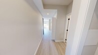 Located on the sixth floor at 829 1st Ave SW in Calgary, this two-bedroom, one-bathroom unit offers a well-planned single-level layout with clean, contemporary finishes throughout. Light wood-toned luxury vinyl flooring runs continuously through the space, complementing the neutral warm-grey wall palette that creates a cohesive and modern aesthetic.

The open-concept kitchen and living area serves as the heart of the unit. The kitchen features two-tone cabinetry — warm natural wood upper cabinets paired with grey lower cabinets — alongside stainless steel appliances, an under-cabinet range hood, and a single-basin sink. Recessed lighting illuminates the space, while baseboard heating ensures year-round comfort.

A welcoming hallway connects the main living area to the two bedrooms, each offering natural light through large windows with views of the surrounding Calgary neighbourhood and treetops. The primary bedroom is a well-proportioned retreat, while the second bedroom includes a built-in closet with panelled bifold doors, making it equally functional as a guest room or home office.

The bathroom is finished with clean white walls, a full-sized soaker tub and shower combo, and sleek matte black fixtures that provide a modern contrast. The overall ambiance of the unit is bright, minimal, and move-in ready.