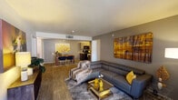 This single-floor residence offers a thoughtfully designed open-concept layout that seamlessly connects the living, dining, and kitchen areas. The spacious living room features wood-look flooring, a large sectional sofa, and bold artwork that adds a warm, contemporary character to the space. A sliding glass door leads to a private outdoor balcony, filling the room with natural light.

The kitchen is equipped with dark wood cabinetry, a mosaic tile backsplash, light quartz-style countertops, a double stainless steel sink, and black appliances. An adjacent dining area provides a dedicated space for meals and entertaining.

The residence includes two well-proportioned bedrooms, each featuring plush carpet flooring, large windows that invite natural light, and ceiling fans for comfort. The primary bedroom offers generous proportions with patterned curtains and ample space for furnishings.

Both bathrooms are finished with wood-look tile flooring, light countertops, dark cabinetry vanities, and full-size tub and shower combinations with tiled surrounds. Large mirrors enhance the sense of space in each bathroom.

A dedicated in-unit laundry area houses a full-size washer and dryer set, complemented by open shelving for additional storage. This residence combines practical functionality with a clean, modern aesthetic throughout.