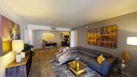 This single-floor residence offers a thoughtfully designed open-concept layout that seamlessly connects the living, dining, and kitchen areas. The spacious living room features wood-look flooring, a large sectional sofa, and bold artwork that adds a warm, contemporary character to the space. A sliding glass door leads to a private outdoor balcony, filling the room with natural light.

The kitchen is equipped with dark wood cabinetry, a mosaic tile backsplash, light quartz-style countertops, a double stainless steel sink, and black appliances. An adjacent dining area provides a dedicated space for meals and entertaining.

The residence includes two well-proportioned bedrooms, each featuring plush carpet flooring, large windows that invite natural light, and ceiling fans for comfort. The primary bedroom offers generous proportions with patterned curtains and ample space for furnishings.

Both bathrooms are finished with wood-look tile flooring, light countertops, dark cabinetry vanities, and full-size tub and shower combinations with tiled surrounds. Large mirrors enhance the sense of space in each bathroom.

A dedicated in-unit laundry area houses a full-size washer and dryer set, complemented by open shelving for additional storage. This residence combines practical functionality with a clean, modern aesthetic throughout.