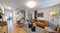 Located at 43 Burt Latham Rd in Willington, Connecticut, this two-floor residence offers a well-organized and thoughtfully designed layout across both levels. The main living area welcomes visitors with warm hardwood flooring, a textured ceiling, and an open, inviting atmosphere. A staircase with sleek metal railings connects the two floors, adding a modern architectural touch to the space.

The kitchen is a standout feature, equipped with soft blue-grey shaker-style cabinetry, white countertops, a geometric patterned tile backsplash, and a full suite of stainless steel appliances including a range, microwave, dishwasher, and refrigerator. Hardwood floors continue throughout, and a drop ceiling provides a clean, finished look.

The bedrooms are comfortably sized, each featuring carpet flooring and natural light from windows with blinds. One bedroom includes a mirrored sliding closet, while another offers a cozy, well-lit layout ideal for restful living. The bathroom features a full tub-shower combination with built-in shelving and hardwood flooring.

A dedicated dining area with hardwood floors, colorful curtains, and a compact round table adds functional charm. Throughout the home, the design balances practical living with a warm, eclectic aesthetic.
