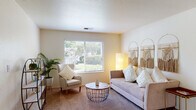 Located at 1959 Lake Blvd in Davis, California, this single-floor residence offers a well-organized layout designed for comfortable everyday living. The living room is bright and inviting, with a large window that draws in natural light and provides views of the surrounding greenery. Soft carpeting and neutral-toned walls contribute to a warm, relaxed ambiance throughout.

The kitchen is fully equipped with ample oak cabinetry, generous counter space, black appliances including a range and refrigerator, and a double sink. A breakfast bar with seating connects the kitchen to the adjacent dining area, which features a ceiling fan and a sliding glass door that opens to an outdoor space.

The unit includes multiple bedrooms, each carpeted and filled with natural light from sizable windows with blinds. The primary bedroom offers a built-in closet with shelving, while additional bedrooms provide flexible space suitable for sleeping or studying. Two bathrooms serve the unit, each featuring an oak vanity with a single sink, tile flooring, and well-lit mirrors. The overall design is functional and consistent, with a neutral color palette maintained throughout every room.