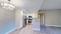 Located at 1163 Hopper Ave in Santa Rosa, CA, this well-designed 2-bedroom, 2-bathroom single-story unit offers a thoughtful layout with modern finishes throughout. Light wood-tone flooring flows seamlessly across all rooms, creating a cohesive and contemporary aesthetic.

The kitchen is a standout feature, outfitted with stainless steel appliances including a gas range, over-the-range microwave, refrigerator with ice maker, and dishwasher. Crisp white cabinetry extends to the ceiling for ample storage, while granite countertops and a peninsula with a deep sink add both style and functionality. Recessed lighting and a pendant fixture illuminate the space.

The living room is bright and open, enhanced by a ceiling fan, neutral gray walls, and sliding glass doors that lead to an outdoor patio with views of the surrounding area. Both bedrooms feature the same warm wood flooring, natural light from exterior windows, and sliding closet doors. The primary bedroom is generously proportioned and connects to the hallway with easy access to both bathrooms.

The two bathrooms are finished in a clean, neutral palette. One features a full tub-shower combo with a curved curtain rod, while the other includes a granite-topped vanity with white cabinetry and tile flooring. A connecting hallway ties all rooms together efficiently, completing this well-appointed single-floor residence.