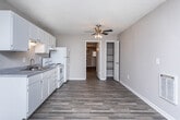 Located at 310 Northlake Dr in Warner Robins, Georgia, this single-floor home offers a practical and well-organized layout designed for comfortable everyday living. Throughout the interior, durable wood-look plank flooring provides a cohesive and clean aesthetic, complemented by neutral-toned walls and textured ceilings that add subtle character to each room.

The living area is open and inviting, featuring a wall-mounted heater unit, a window that allows natural light to filter in, and a straightforward entry door that connects to the outdoors. The space is clean and move-in ready, offering a blank canvas for personalization.

The kitchen is efficiently designed with a full run of white cabinetry providing generous upper and lower storage, a double-basin sink with laminate countertops, and white appliances including an electric coil range with oven and a full-size refrigerator. A range hood is installed above the stove for ventilation.

Additional rooms include bedrooms with closet storage and connecting hallways that allow for smooth circulation throughout the home. One room features a wall-mounted air conditioning unit, a ceiling light fixture, and an exterior door with a window, offering direct outdoor access.

Overall, this home presents a clean, functional interior with consistent finishes and practical amenities suited for residential use in Warner Robins, GA.