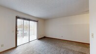 Located at 1985 N Amidon Ave in Wichita, Kansas, this single-floor residence offers two bedrooms and three bathrooms within a well-organized layout. The combined living and dining area serves as the heart of the home, featuring plush carpeting, a textured ceiling, and a classic fireplace framed in warm wood trim. Large sliding glass doors with vertical blinds flood the space with natural light and provide access to an outdoor area. The open-concept kitchen is equipped with warm oak cabinetry, a built-in breakfast bar with generous counter space, a stainless steel sink, and a full suite of appliances including a range, microwave, and refrigerator. Both bedrooms are carpeted and bright, each featuring ceiling fans and windows with vertical blinds. The spacious primary bedroom offers ample room for furnishings, while the second bedroom provides a comfortable and functional space. Three bathrooms, finished with wood-tone accents and hard surface flooring, serve the home efficiently. Three closets provide plentiful storage, and a dedicated laundry area adds everyday convenience. A connecting hallway with neutral tones and carpeting ties the layout together seamlessly, creating a cohesive and practical living environment.