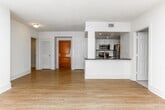 Located at 200 Colonial Homes Dr NW in Atlanta's 30309 zip code, this single-floor residence offers a clean, modern aesthetic throughout its open-concept layout. Light wood-style flooring flows seamlessly through the main living areas, enhancing the bright, airy feel of the space.

The kitchen is designed for functionality and style, featuring white cabinetry, dark countertops, and a full suite of stainless steel appliances including a refrigerator, range, microwave, and dishwasher. A peninsula with a dual-basin sink connects the kitchen to the living area, creating an ideal space for entertaining. The open living and dining area is generously proportioned, bathed in natural light from large sliding glass doors that lead to a private balcony.

The bedroom area offers plush carpeting, a ceiling fan, and its own sliding glass door access to the balcony. A spacious walk-in closet with built-in wire shelving and rack systems provides ample organized storage. Two full bathrooms serve the residence, each finished with white cabinetry, dark countertops, undermount sinks, and a tub/shower combination. The overall palette of crisp whites and neutral tones lends a clean, contemporary character to every room.