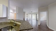 This well-appointed 2-bedroom, 2-bathroom residence in Charlotte, NC offers a thoughtfully designed single-level layout. The open-concept living and dining area is anchored by rich hardwood-style flooring, crown molding, and a ceiling fan, creating a warm and inviting atmosphere. Large sliding glass doors flood the living room with natural light and open directly onto a private balcony with outdoor views, complemented by additional windows that enhance the bright, airy feel of the space.

The kitchen is a standout feature, boasting granite countertops, crisp white cabinetry, and a full suite of stainless steel appliances including a refrigerator, electric range, built-in microwave, and dishwasher. A curved breakfast bar seamlessly connects the kitchen to the dining and living areas, ideal for both everyday living and entertaining.

Each bedroom is generously proportioned, featuring ceiling fans, wood-style flooring, and ample natural light. The primary bedroom includes a private en-suite bathroom with granite vanity countertops. The second bathroom mirrors this quality, featuring a tub/shower combination and matching finishes. Additional highlights include multiple closets for storage, a dedicated laundry area, and clean, neutral tones throughout that create a move-in-ready environment.