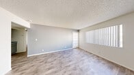 Located at 3955 E Charleston Blvd in Las Vegas, NV, this single-floor residence offers three bedrooms and two full bathrooms across a thoughtfully laid-out floor plan. The living room greets you with light-toned wood-look flooring, soft gray walls, a textured ceiling, and large windows fitted with vertical blinds that invite natural light throughout the day. An open sightline connects the living area to the kitchen, which features speckled granite-style countertops, gray shaker-style cabinetry, a ceiling fan, and wood-look flooring, creating a clean and functional cooking space. The bedrooms offer a calm retreat, with the primary bedroom providing a generous footprint, plush carpet flooring, a wide window with vertical blinds, and a closet with sliding doors. The two additional bedrooms share similar finishes. Both bathrooms are finished with wood-look flooring, white tiled tub-shower combos, chrome fixtures, and vanities with speckled countertops. Two closets provide practical storage throughout the unit. The overall aesthetic is clean and contemporary, with a neutral color palette, consistent flooring choices, and updated finishes that create a cohesive and comfortable living environment.
