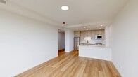 Located at 2140 North Lincoln Park West in Chicago's coveted Lincoln Park neighborhood, this thoughtfully designed one-bedroom, one-bathroom residence offers a clean, modern aesthetic throughout. Light hardwood flooring runs continuously across the entire space, creating a cohesive and airy feel.

The open-concept kitchen and living area serves as the heart of the home. The kitchen is well-appointed with shaker-style cabinetry in a warm taupe finish, white quartz countertops, a subway tile backsplash, stainless steel appliances including a full-size refrigerator and dishwasher, and a peninsula that provides additional prep space and a natural divide from the living area. Recessed lighting illuminates the kitchen efficiently.

A bright hallway with recessed lighting connects the living area to the private quarters. The bedroom is a comfortable retreat, featuring a large picture window that frames outdoor views of the surrounding neighborhood and fills the room with natural light. A spacious closet with built-in shelving provides ample storage, complemented by a secondary closet with a sliding barn-style door.

The bathroom showcases a sleek, glass-enclosed walk-in shower with textured white tile walls, geometric mosaic floor tile in charcoal tones, and matte black fixtures, delivering a refined, spa-like finish.