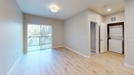 Located at 8445 Pacific Ave in Tacoma, WA, this well-designed one-bedroom, one-bathroom unit offers a thoughtful open-concept layout across a single floor. Light-toned hardwood-style flooring runs throughout the main living areas, complementing the neutral gray walls and recessed lighting that keep the space feeling bright and contemporary.

The kitchen and living room share a seamless open floor plan. The kitchen is equipped with warm wood cabinetry, a white quartz peninsula with an integrated sink, and a full suite of stainless steel appliances including a refrigerator, range, microwave, and dishwasher. The adjacent living area benefits from a sliding glass door that opens to a private balcony, flooding the room with natural light.

The bedroom features plush carpet flooring, a sliding closet, and a window with outdoor views. Additional storage is well-served by multiple closets throughout the unit. An in-unit laundry area adds everyday convenience.

The bathroom is a standout feature, offering a wide wood-toned vanity with a white quartz countertop, a round mirror flanked by sconce lighting, built-in shelving, and a full soaking tub with tile surround. The overall aesthetic is clean, modern, and move-in ready.