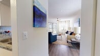 This single-story residence offers a thoughtfully designed layout that connects its living spaces in a functional and comfortable flow. The living room serves as the central gathering area, featuring wood-style flooring, a ceiling fan, and large windows dressed with floor-length curtains that invite generous natural light. A pass-through opening connects the living area to the kitchen, which is outfitted with white shaker-style cabinetry, granite-look countertops, and stainless steel appliances including a range, over-the-range microwave, and dishwasher. The layout also accommodates a dining nook near the windows, ideal for casual meals.

The two bedrooms are carpeted for comfort and each features a ceiling fan, a window with blinds and curtain panels, and ample wall space. The textured ceilings carry throughout the unit, lending a consistent architectural character.

Both bathrooms are finished with wood-style flooring, granite-topped vanities with white cabinetry, and tub-shower combinations with curtain enclosures. Neutral wall tones throughout the residence create a versatile backdrop, while the overall design balances practicality with a clean, contemporary aesthetic.