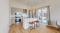 Located at 600 West State Street in Kennett Square, PA, this thoughtfully designed one-bedroom, one-bathroom residence offers a modern aesthetic with high ceilings and light wood flooring throughout. The open-concept layout connects the kitchen, dining, and living areas into a cohesive, airy space filled with natural light from large windows.

The kitchen is a standout feature, showcasing light wood cabinetry, open shelving, a white quartz island with bar seating, stainless steel appliances, and pendant lighting. Glass sliding doors lead directly to a private balcony, seamlessly blending indoor and outdoor living.

The living room is bright and welcoming, with soaring ceilings and multiple windows that frame outdoor views, creating an expansive feel well beyond its footprint. A clean hallway with recessed lighting and framed wall art connects the main living areas to the private spaces.

The bedroom is a serene retreat, featuring plush carpeting, elevated ceilings, and a large window that invites ample natural light. A generously sized walk-in closet with wire shelving provides practical storage. The bathroom is finished with light wood vanity cabinetry, a white countertop, a large mirror, and contemporary lighting fixtures, all set on warm hardwood flooring for a clean, cohesive look.