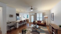 Located at 1550 Westborough Dr in Houston, TX, this single-floor residence offers a thoughtfully designed open-concept layout that seamlessly connects the living, dining, and kitchen areas. Rich hardwood-style flooring runs throughout the main living spaces, anchoring a bright and welcoming atmosphere enhanced by multiple windows that invite natural light.

The kitchen is a standout feature, showcasing dark espresso cabinetry, stainless steel appliances, a gas range, and a granite-topped breakfast bar with pendant lighting — ideal for both casual dining and entertaining. Track lighting and a ceiling fan add functional style to the living area, which offers ample room for relaxed seating arrangements.

The bedrooms are carpeted for comfort, each featuring ceiling fans, large windows with blinds, and generous wall space. The primary bedroom includes a striking abstract accent wall, adding a bold design element to the serene retreat.

Two bathrooms serve the residence, each finished with dark vanity cabinetry, hardwood-style flooring, and well-lit mirror configurations. One bathroom includes a walk-in glass shower, while the other offers a shower-tub combination, providing practical versatility.

Overall, the space balances modern finishes with a warm, livable aesthetic throughout every room.