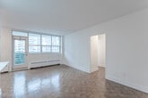Located on the 15th floor at 85 Redpath Avenue in Toronto's vibrant Midtown neighbourhood, this 2-bedroom, 1-bathroom unit offers a functional and well-appointed layout across a single floor. Warm parquet flooring flows throughout the living areas and bedrooms, adding a classic character to the bright, white interior. The open living and dining area is bathed in natural light from a large floor-to-ceiling window wall, and provides direct access to one of two private balconies, framing impressive city skyline views. A second balcony is accessible from the primary bedroom, which also features a sliding closet and its own window overlooking the cityscape. The second bedroom includes built-in closet storage and a window with views of surrounding towers. The kitchen is clean and efficiently designed with white cabinetry, stainless steel appliances including a full-size refrigerator, and tile backsplash. A bright entryway with vinyl flooring connects the kitchen to the front door. The full bathroom features a soaker tub with overhead shower, white tile surround, and chrome fixtures. Baseboard heating is present throughout, and the unit's crisp white walls complement the warm tones of the parquet floors for a balanced, inviting atmosphere.