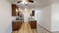 Located at 59 Reid Terrace in Fond du Lac, Wisconsin, this two-bedroom, one-bathroom residence offers a well-designed single-floor layout. The galley-style kitchen is a standout feature, showcasing rich dark wood cabinetry, granite countertops, stainless steel appliances including a range, microwave, refrigerator, and dishwasher, and light hardwood-style flooring that flows into the adjoining living area. A ceiling fan adds comfort to the open kitchen-living space, which benefits from natural light through well-placed windows.

The two bedrooms offer distinct finishes — one with warm hardwood-style flooring, a ceiling fan, and a mirrored sliding-door closet, while the other features plush carpet, a large window with outdoor views, and a baseboard heating system. Three closets throughout the unit provide generous storage.

The bathroom is thoughtfully finished with a granite-top vanity set in dark wood cabinetry, a framed mirror, marble-tile surround in the tub and shower, and hardwood-style flooring. An additional linen closet is conveniently located just outside the bathroom. Clean white walls and neutral tones throughout create a cohesive, move-in-ready atmosphere.