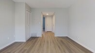 This 520 square foot apartment in Louisville, Kentucky, maximizes functionality within its compact layout. The single-floor design includes one bedroom, one bathroom, and an open-concept kitchen and living area. The kitchen showcases modern appliances, including a stainless steel refrigerator, and granite countertops that complement the white cabinetry. Subway tile backsplash adds a contemporary touch.

The bathroom features a marble-look tiled shower surround and a vanity with a granite countertop, mirroring the kitchen's aesthetic. Light wood-look flooring runs throughout the main living areas, while the bedroom is carpeted for comfort. The 140 square foot bedroom includes a closet with sliding doors for storage.

Large windows in the bedroom and French doors in the living area allow ample natural light and provide outdoor views. The neutral color palette, predominantly in shades of white and gray, creates a bright, airy atmosphere throughout. Recessed lighting and modern fixtures further enhance the contemporary feel of this efficiently designed space.