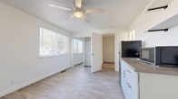 This efficient 1-bedroom, 1-bathroom unit offers a thoughtfully organized layout across a single floor. Light-toned luxury vinyl plank flooring runs continuously throughout the space, creating a clean, cohesive aesthetic that enhances the sense of openness.

The bedroom is a generously proportioned room featuring a ceiling fan with integrated lighting, a large window fitted with horizontal blinds that invites ample natural light and outdoor views of surrounding greenery, and a mirrored sliding-door closet that adds both storage and depth to the room.

The kitchen is designed for practicality, featuring white shaker-style cabinetry, neutral laminate countertops, and a full suite of appliances including a stainless steel refrigerator, a gas range with overhead cabinetry and task lighting, and a countertop sink. The galley-style layout maximizes workspace efficiency.

The bathroom is clean and bright, finished with white tile surrounding a full bathtub and shower combination, complemented by light flooring consistent with the rest of the unit.

Throughout the space, white walls and trim create a bright, neutral palette that offers versatility. A dedicated entryway provides a practical transition into the main living area, completing this well-appointed and move-in-ready unit.