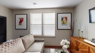 This one-bedroom, one-bathroom unit in Memphis, Tennessee offers a well-designed single-floor layout with modern finishes throughout. The living area features hardwood-style flooring, neutral warm-gray walls, and dual windows fitted with white horizontal blinds that allow for adjustable natural light. The space accommodates a comfortable seating arrangement and has a welcoming, contemporary ambiance.

The kitchen is a functional galley-style design equipped with white cabinetry, granite countertops, stainless steel appliances including a refrigerator, range, and microwave, and a undermount sink. Track lighting illuminates the workspace effectively. An adjacent peninsula with granite countertop and bar seating provides additional dining and prep space, seamlessly connecting the kitchen to the living area.

The bedroom is a calm, well-proportioned retreat with a ceiling fan, a closet with dark panel doors, and neutral tones that promote a restful atmosphere.

The bathroom features dark espresso cabinetry, granite countertops, an undermount sink, a large mirror, and a tiled shower-tub combination with white subway tile surround. Hardwood-style flooring extends throughout, maintaining a cohesive aesthetic across the entire unit.