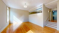 Located at 1601 Main St in downtown Columbia, SC, this single-floor, one-bedroom, two-bathroom unit offers a well-organized layout across a generously sized footprint. The living area is immediately inviting, showcasing warm honey-toned hardwood floors that carry throughout much of the space, abundant natural light, and a distinctive interior glass transom window that adds an architectural accent and visual openness to the main room. A staircase is also visible, adding a subtle design element to the living space.

The kitchen is efficiently designed with ample upper cabinetry in a neutral taupe finish, granite-style countertops, a stainless steel double sink, and black appliances including a refrigerator, dishwasher, and electric range — all set atop the same hardwood flooring.

The expansive primary bedroom offers generous proportions with continued hardwood flooring, neutral wall tones, and access to a dedicated closet. The hallway connects the rooms with a clean, open flow.

Both bathrooms are finished with slate-blue tile flooring. One features a walk-in shower with chrome fixtures, while the other includes a full soaking tub with a shower curtain rod. Warm beige walls and clean white fixtures give both bathrooms a practical yet polished appearance throughout.
