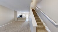 Located at 4115 Britton Pky in Hilliard, Ohio, this two-story home offers a practical and comfortable layout spread across two well-proportioned floors. The main level opens into a bright living room with neutral carpet and a seamlessly connected kitchen featuring white cabinetry, dark countertops, black appliances including a range, microwave, and refrigerator, and light tile flooring. A peninsula counter provides additional workspace and serves as a natural divider between the kitchen and living areas. Natural light filters in through multiple windows throughout the home, enhancing the clean, neutral color palette.

Upstairs, two bedrooms offer carpeted comfort and ample natural light. The primary bedroom features vaulted ceilings and large windows that fill the space with daylight. The second bedroom is well-sized with multiple windows overlooking the outdoors. Two closets provide convenient storage throughout the upper level. A dedicated laundry room with full-size washer and dryer hookups adds everyday practicality.

The home includes three bathrooms in total — one featuring a glass-door walk-in shower, and another with a full soaking tub and shower combination, both finished in clean, neutral tones with white vanities. The staircase connecting both floors is accented with white railings and carpeted treads, tying together the home's cohesive, understated aesthetic.